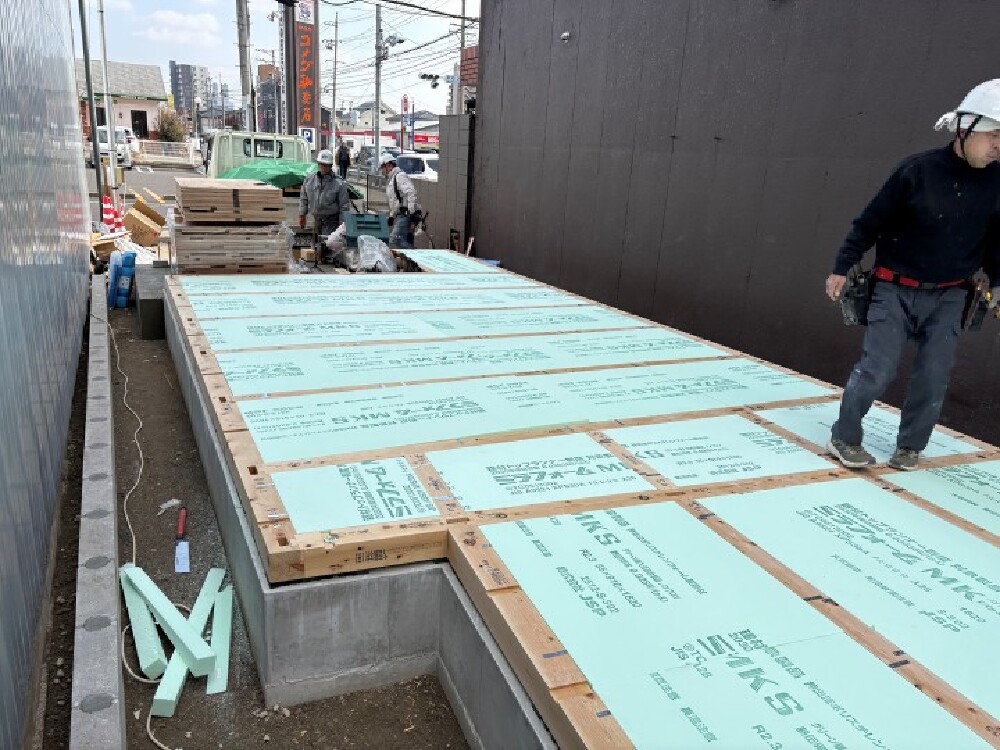 土台間に床断熱材を敷き込む施工の様子