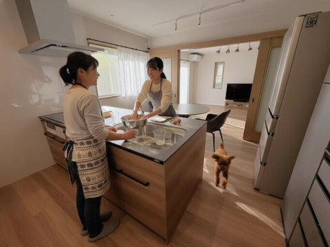 リフォーム後の対面キッチンで、向かい合って料理を楽しむO様ご家族