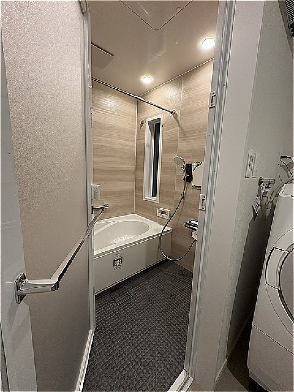 O様邸 浴室リフォーム後 開き戸と手すりを使いやすくするため浴槽の向きを変更した浴室