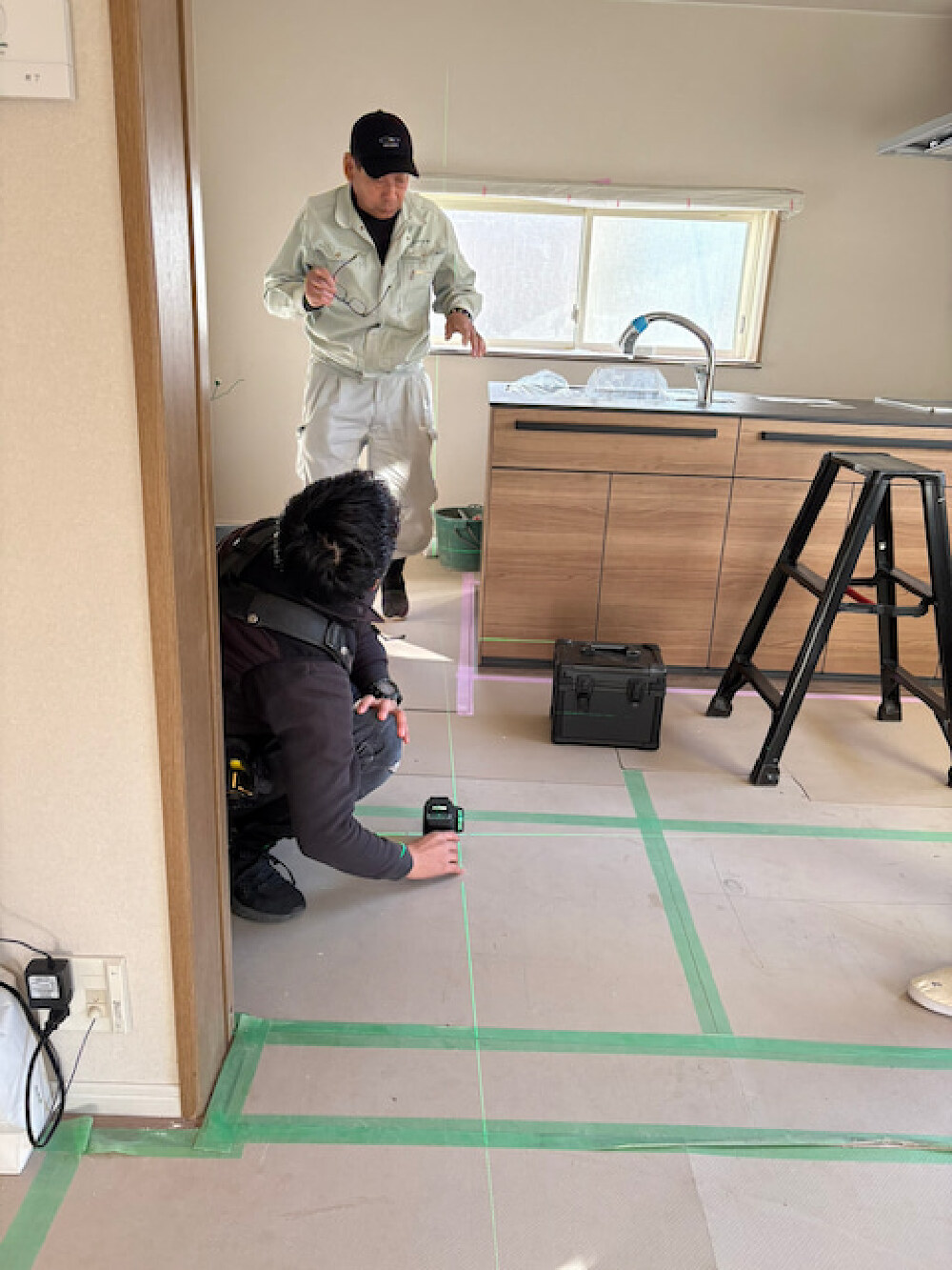 キッチン・ダイニング最終工程、レーザーでダウンライト位置を確認する様子（O様邸）