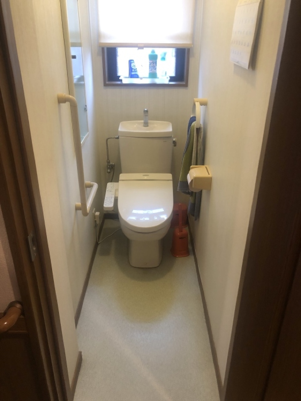 北方町H様邸のリフォーム前1階トイレ。手すり付きで安心感があるが、経年劣化により暗く見える空間。