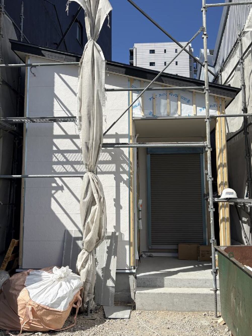 外壁サイディング施工中の住宅外観の様子