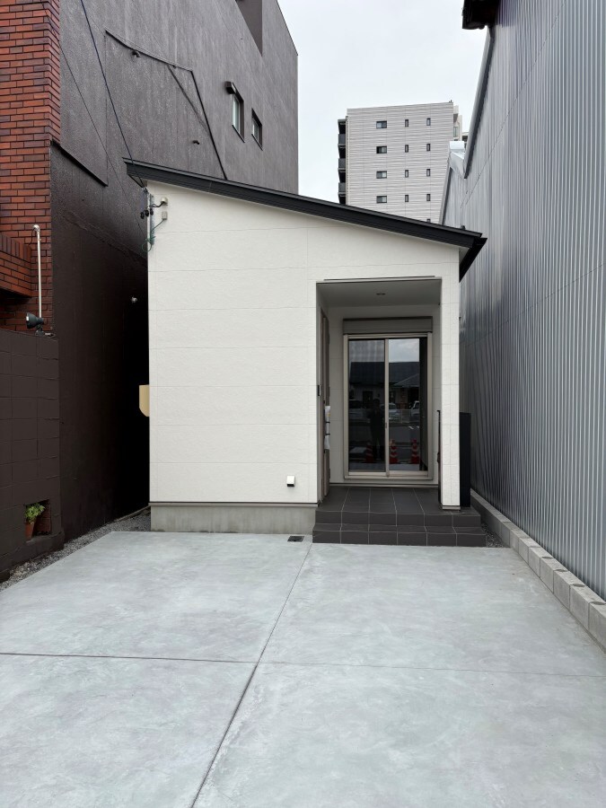 白いサイディング外壁と銀黒の片流れ屋根を組み合わせた、大垣市M様邸のコンパクトな平屋の正面外観