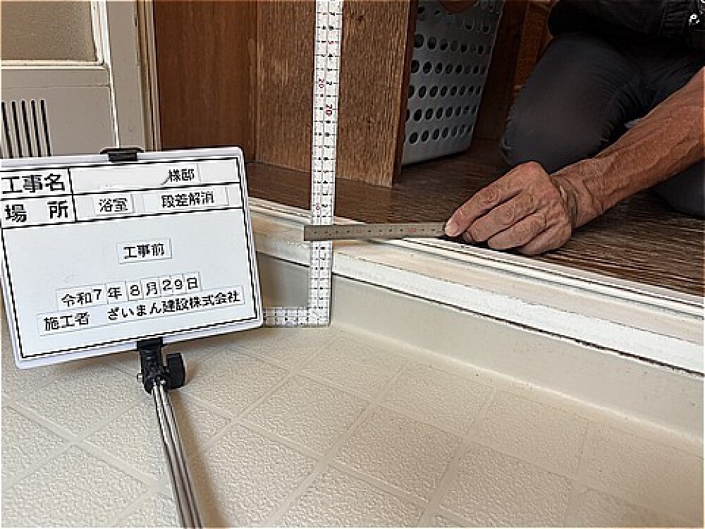 浴室リフォーム前の出入口にある段差を測定している様子｜段差解消工事のBefore写真