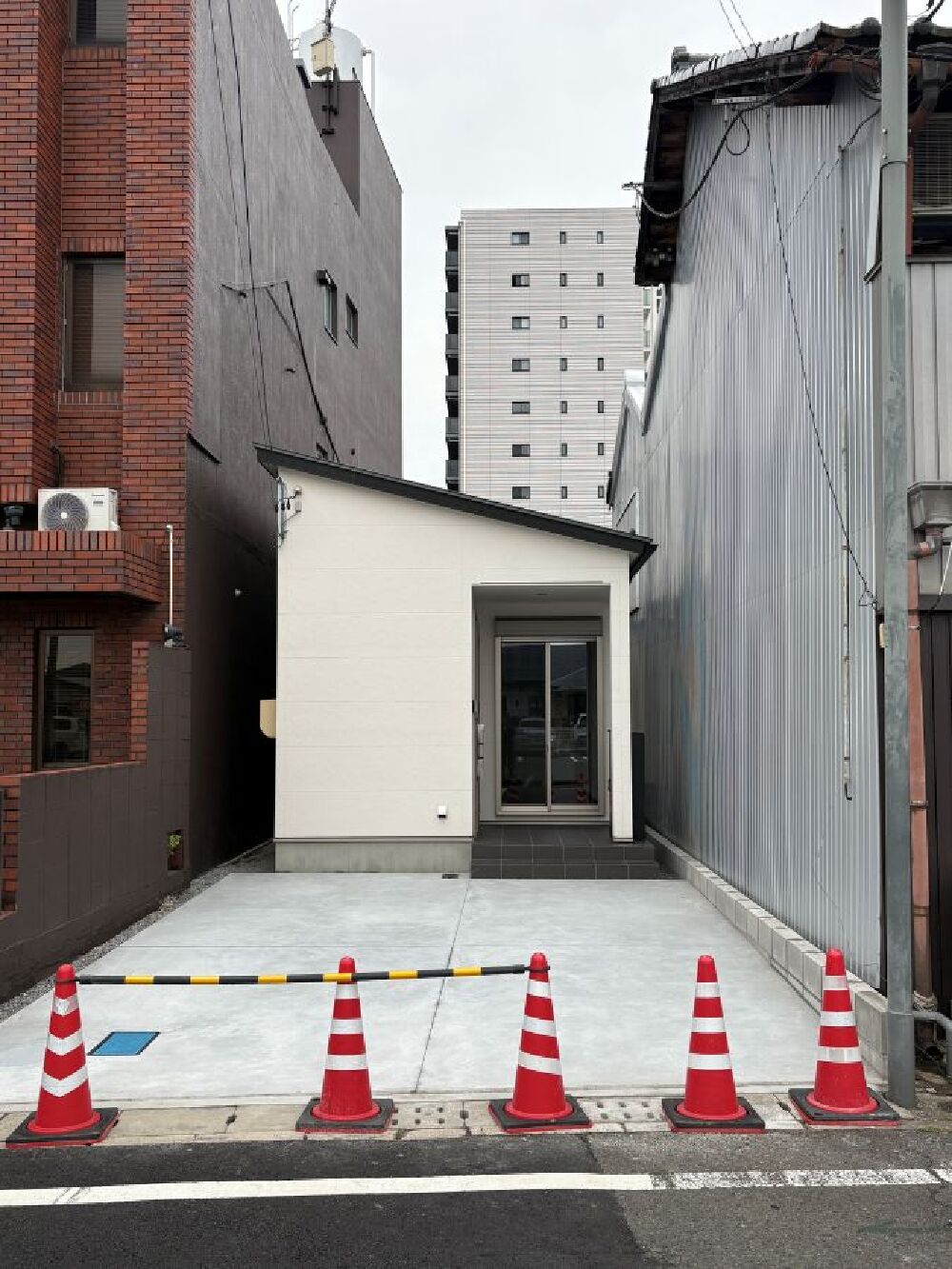土間コンクリートを施工した駐車スペースと完成した住宅外観