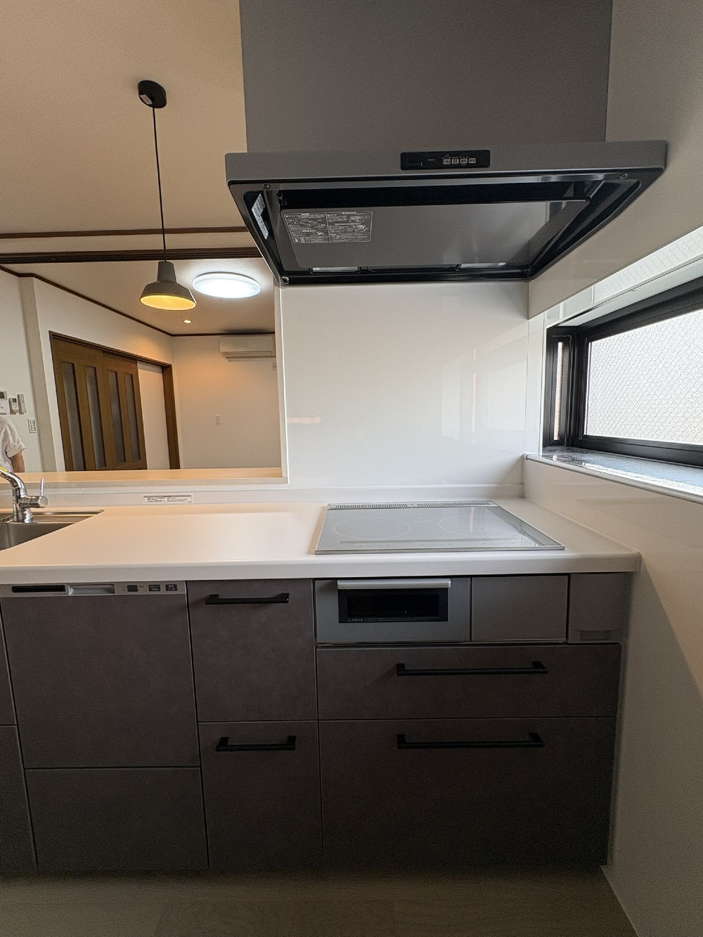 IHクッキングヒーターとスーパークリーンフードを備えたTOTOミッテのキッチン。掃除しやすく清潔感ある空間。